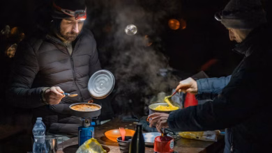 Zwei Motorradfahrer kochen im Dunklen draußen