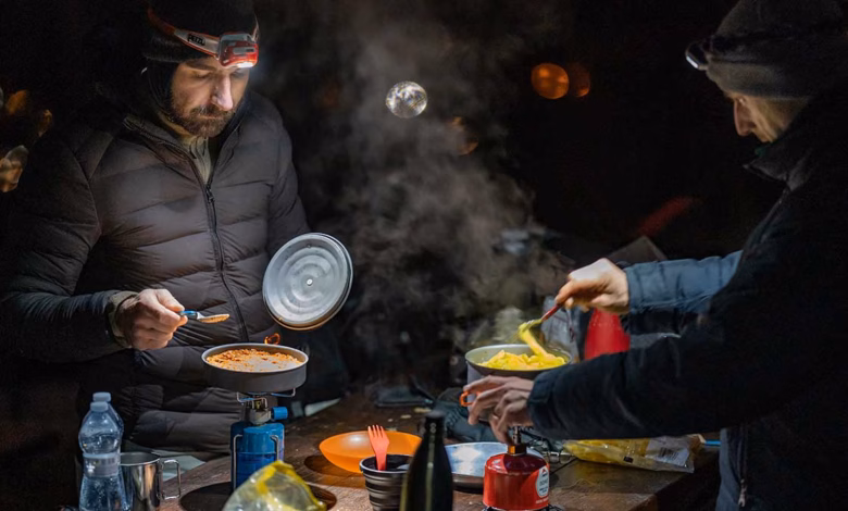 Zwei Motorradfahrer kochen im Dunklen draußen
